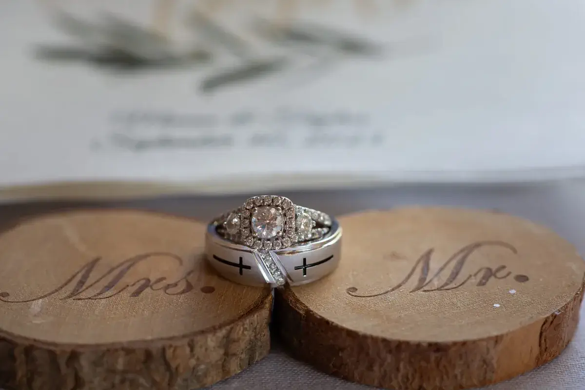 Wedding rings displayed on wood slices reading 'Mr.' and 'Mrs.' at Taylor and Mason's Cedar Hill Farm wedding
