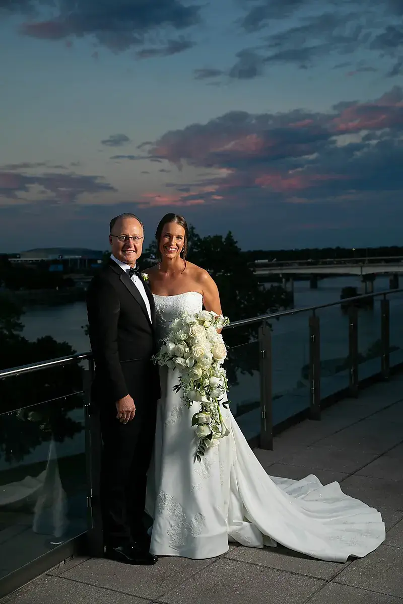 Father and bride on a rooftop terrace at dusk
