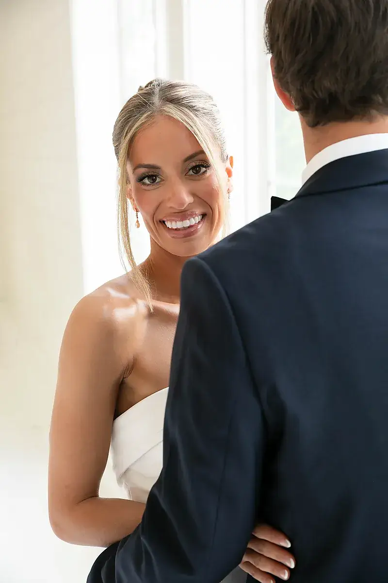 Bride looking over her shoulder at the groom