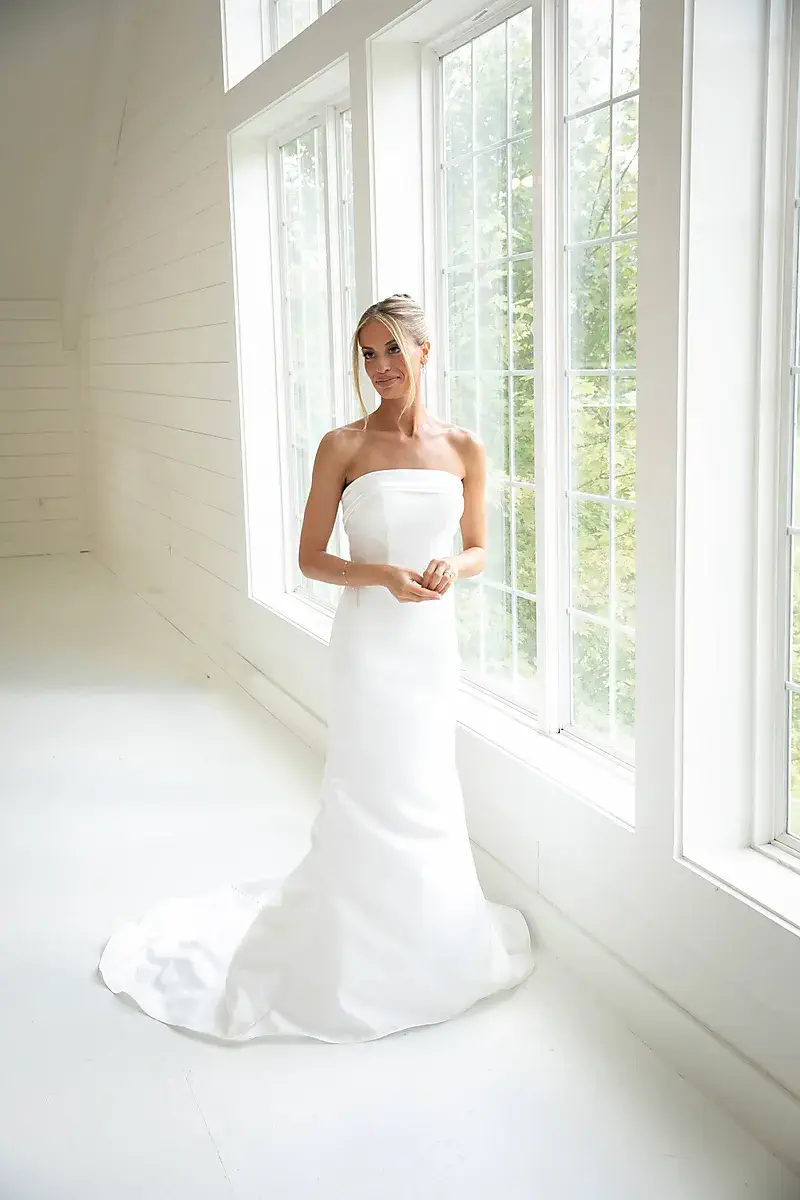 Bride by a bright window in a white room