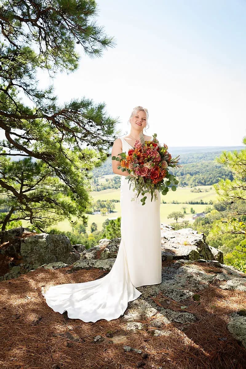 Bride on a rocky overlook with an autumn bouquet