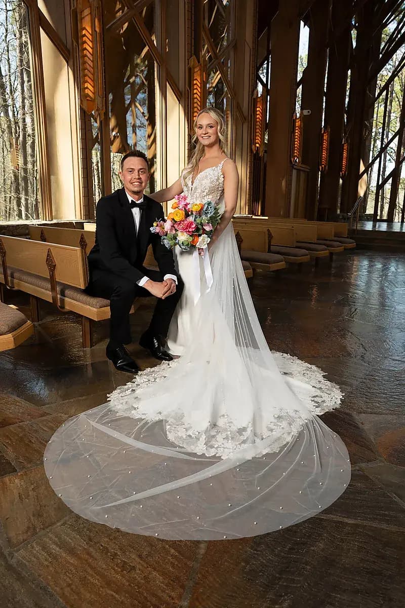Groom kneeling beside his bride in a wooden chapel